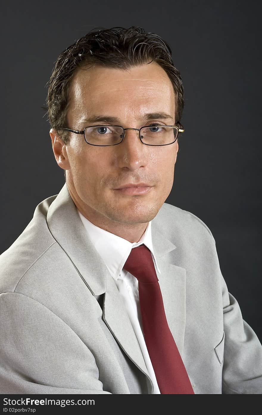 Man In Grey Jacket With Red Tie And Glasses