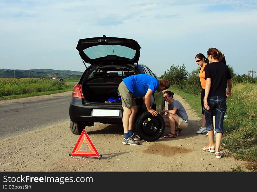 People trying to fix a flat tire