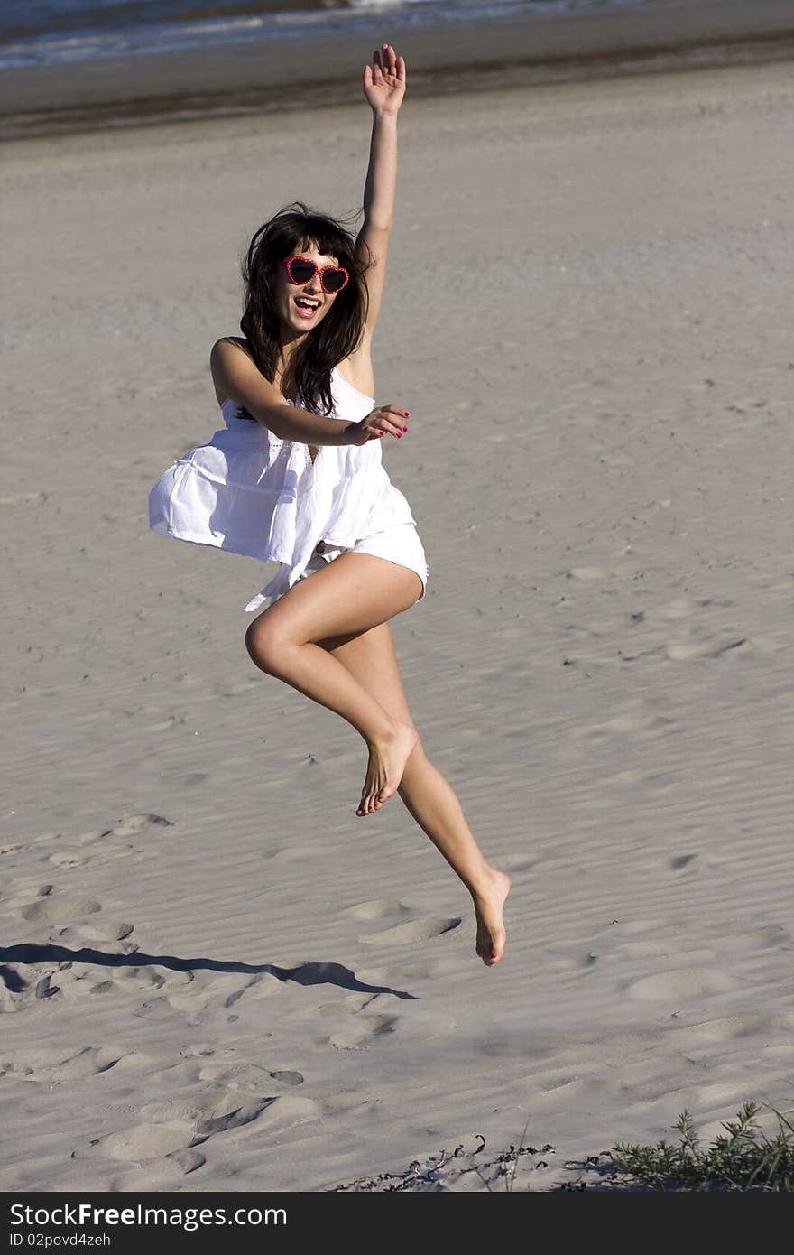 Happy young atractive woman is dancing on the beach. Happy young atractive woman is dancing on the beach