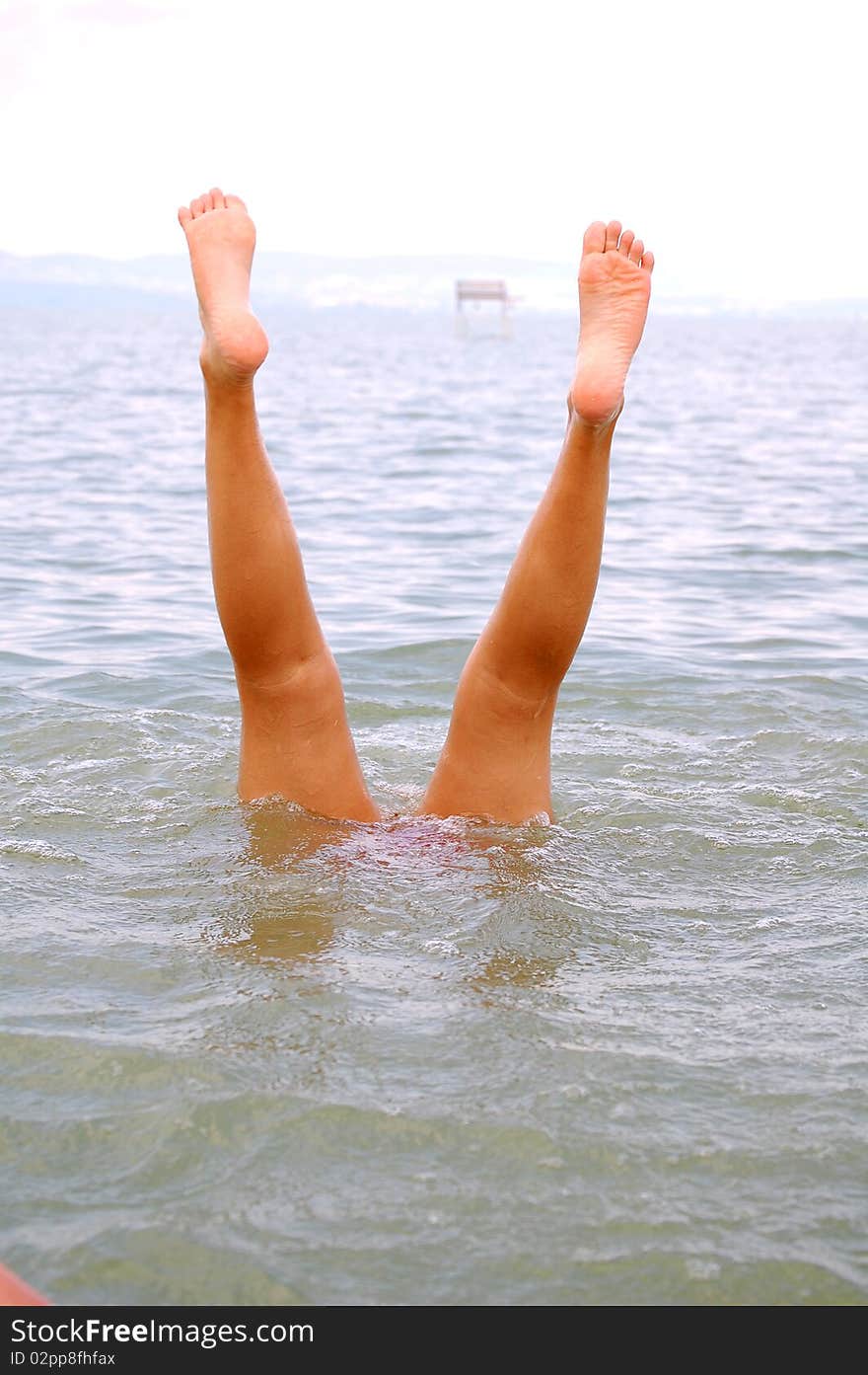 Girl does a handstand in a lake