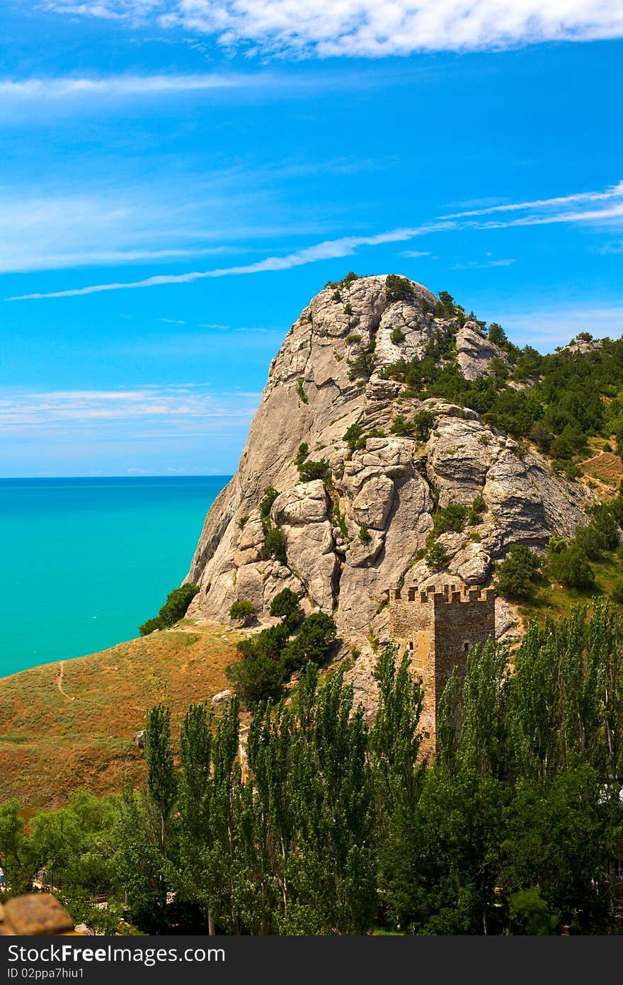 Sudak, Crimea, Ukraine. Rock, sea and single tower view. Sudak, Crimea, Ukraine. Rock, sea and single tower view