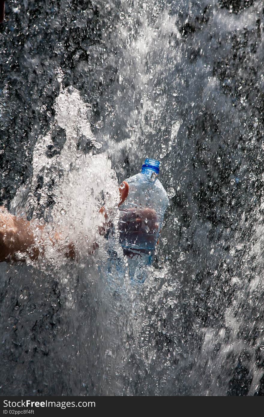 Hand gathering water in a bottle of water at the source