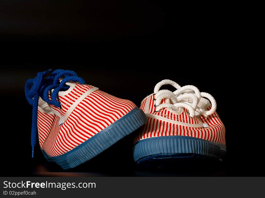 A pair of retro girls sneakers isolated on black background