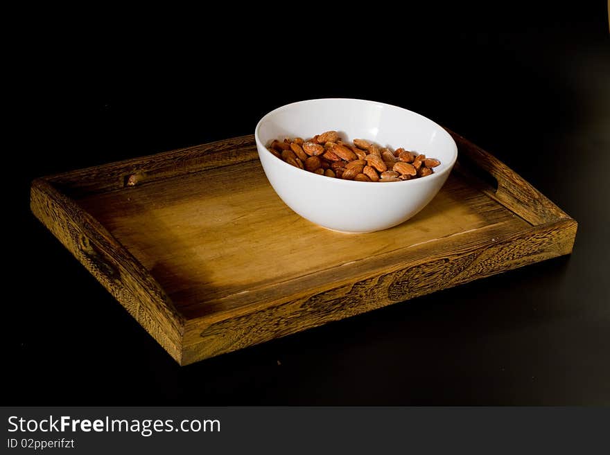 Bowl with almonds on wooden tray