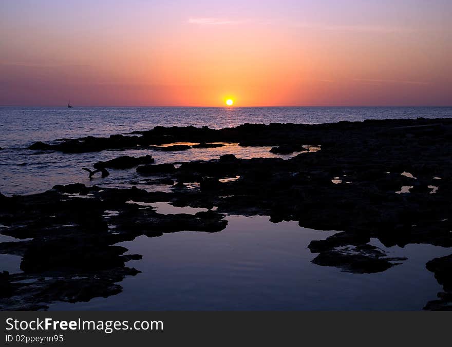 Bright sunset under the indented seashore