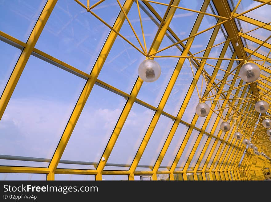 Transparent glass roof, with fixtures suspended inside.