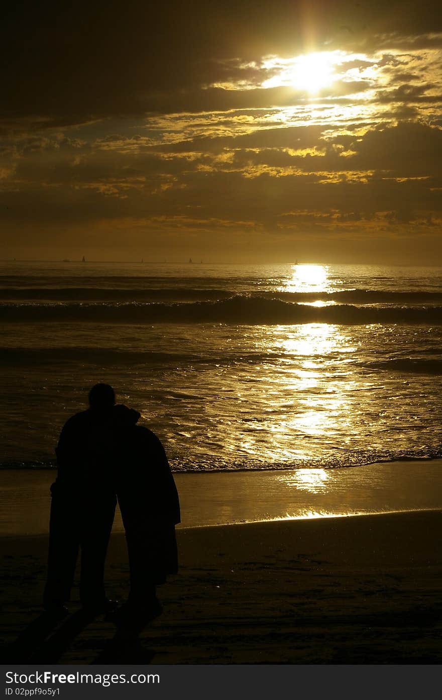 Couple standing before the ocean sunset. Couple standing before the ocean sunset.