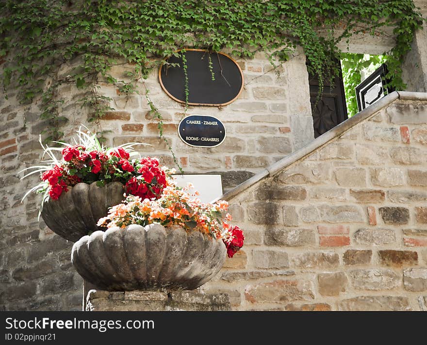 Exterior hotel and resturan sign in a stone wall with flower. Exterior hotel and resturan sign in a stone wall with flower