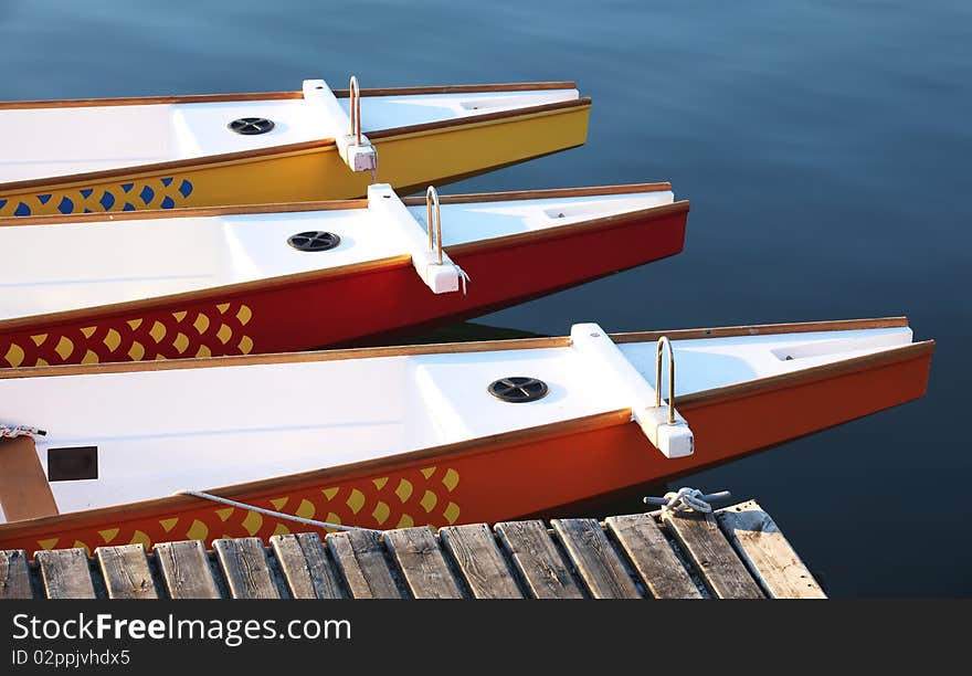 Three Colorful Paddle Boats At A Dock