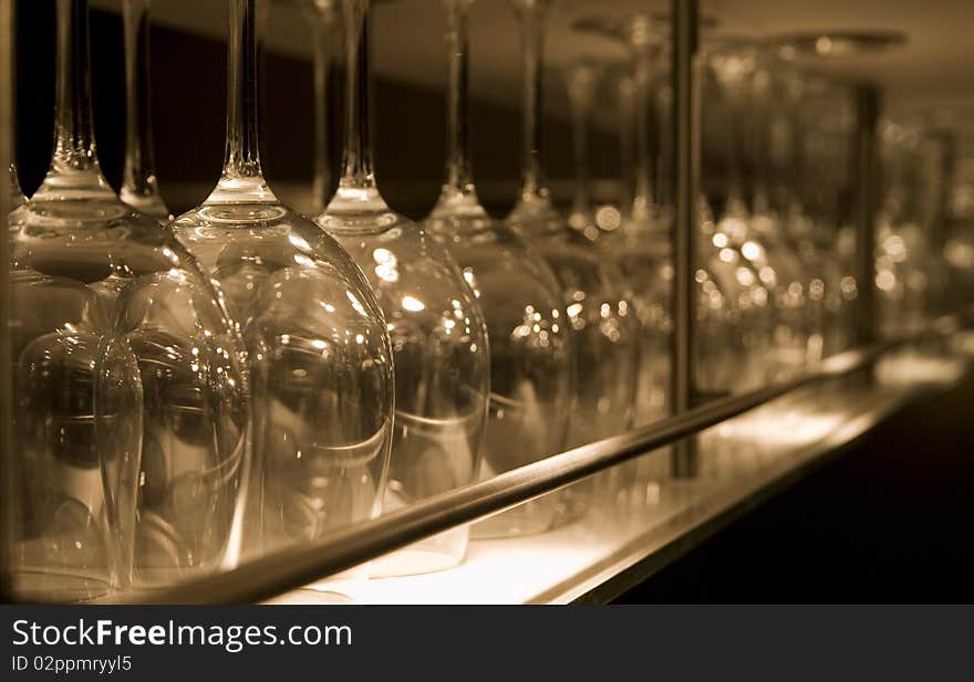 Row of clean wine glasses in a stainless steel rack in a modern bar. Row of clean wine glasses in a stainless steel rack in a modern bar