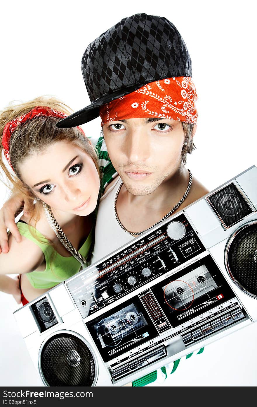 Couple of trendy teenagers posing together over black background. Couple of trendy teenagers posing together over black background.