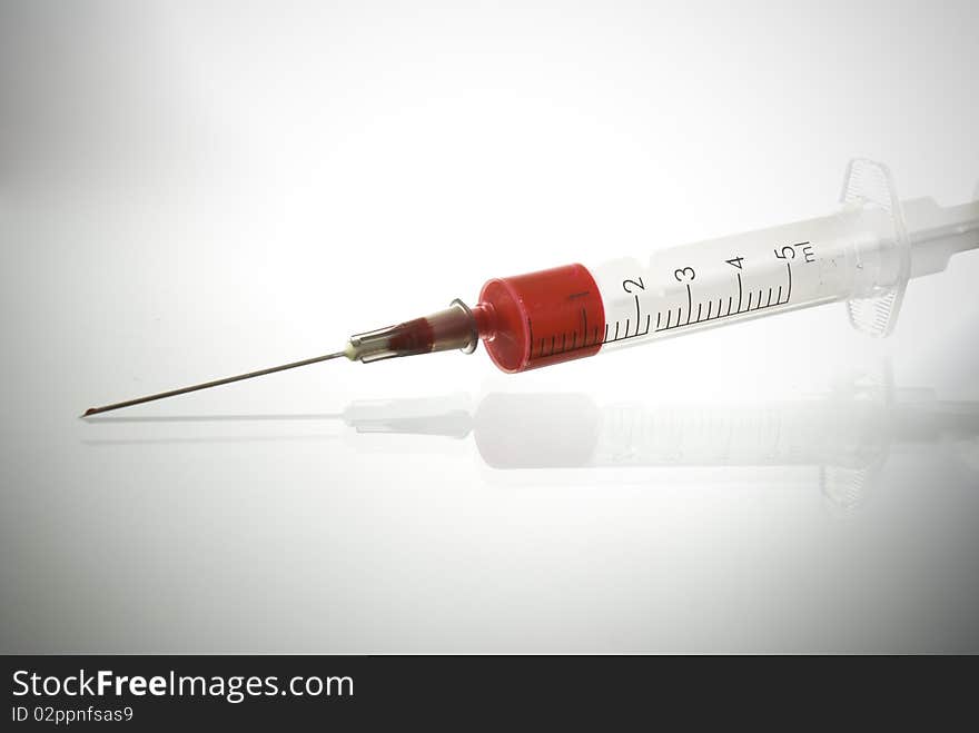 Photo of Medical Syringe on glossy background