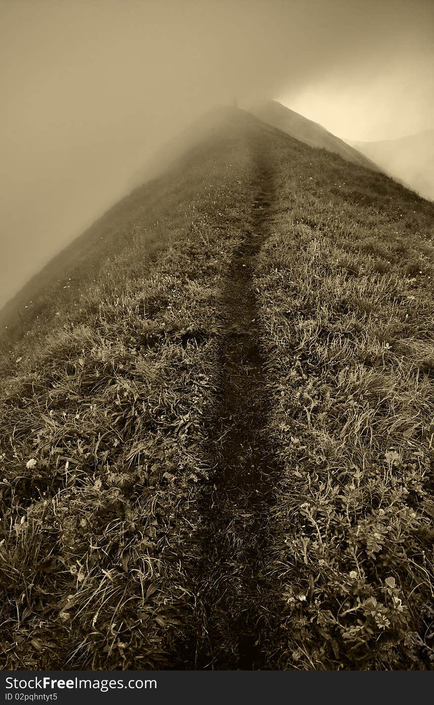 Dirt road leading to the a high mountain pass. Dirt road leading to the a high mountain pass.