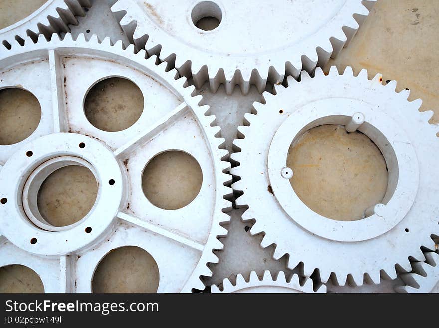 Set of big industrial metallic gears on the concrete floor background. Set of big industrial metallic gears on the concrete floor background