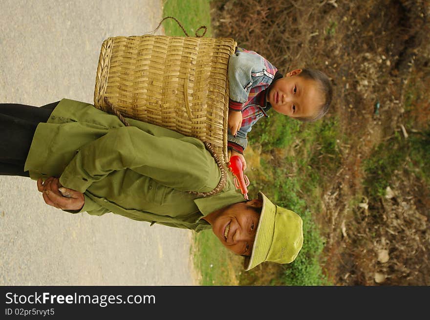 Grandfather Hmong and her small son in the cart. The road is long and the baby is tired. Grandfather Hmong and her small son in the cart. The road is long and the baby is tired.