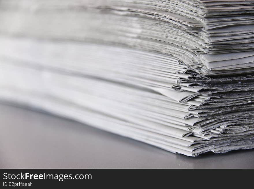 This image shows a stack of newspapers piled