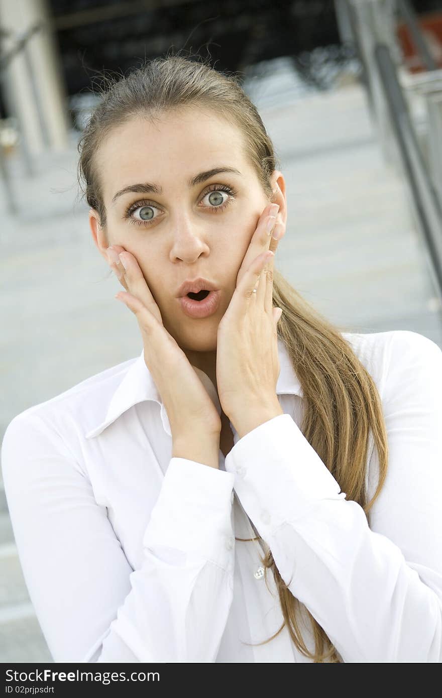 Young business woman expressed surprise. His hands are on her cheeks. Young business woman expressed surprise. His hands are on her cheeks