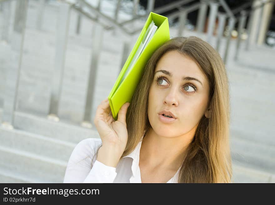 Attractive young businesswoman smiling with a green folder. Attractive young businesswoman smiling with a green folder.