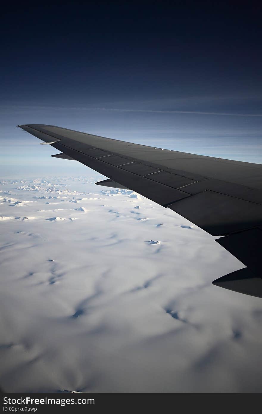 Left wing over Greenland on the dark sky