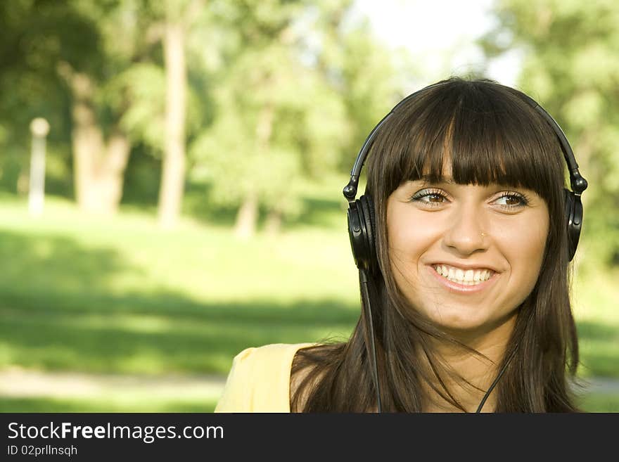 Smiling young woman listening to music at park