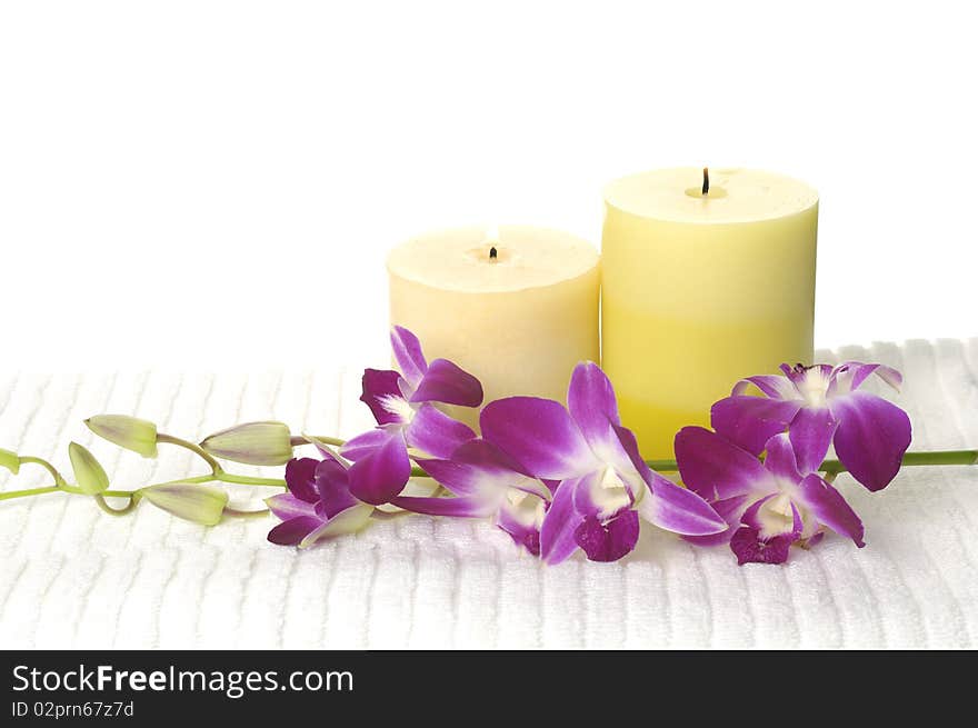 A beautiful orchid, towel and candles. A beautiful orchid, towel and candles