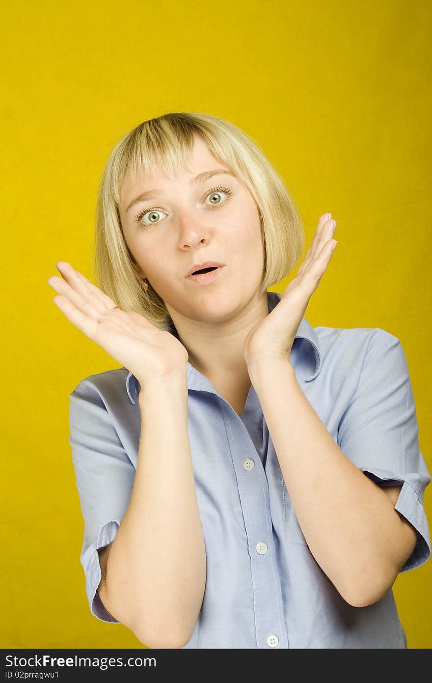 Young woman expressing emotions on a yellow background