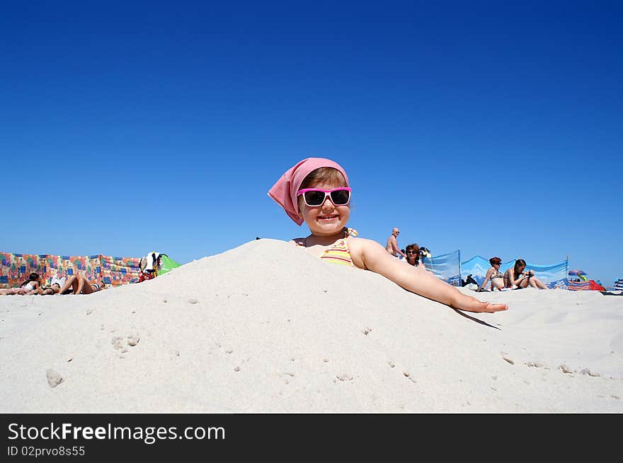 Little girl in pink glasses, sitting on the beach. Little girl in pink glasses, sitting on the beach