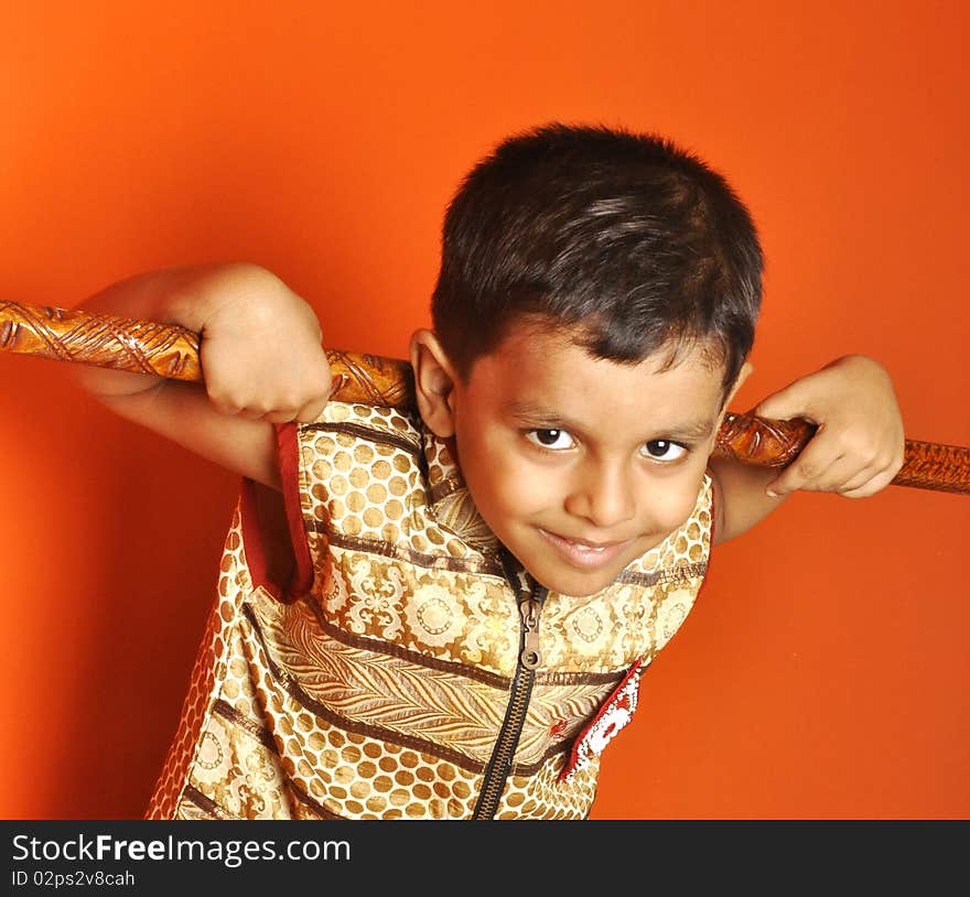 A mischievous boy from an Indian village posing with a wooden club. A mischievous boy from an Indian village posing with a wooden club.