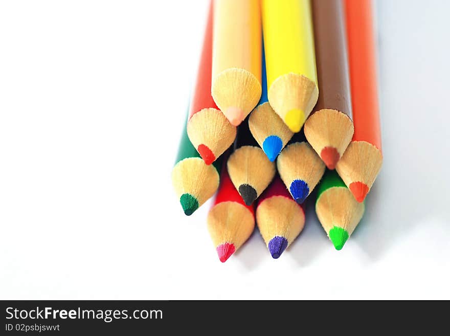 Close up of color pencils with different color over white background.