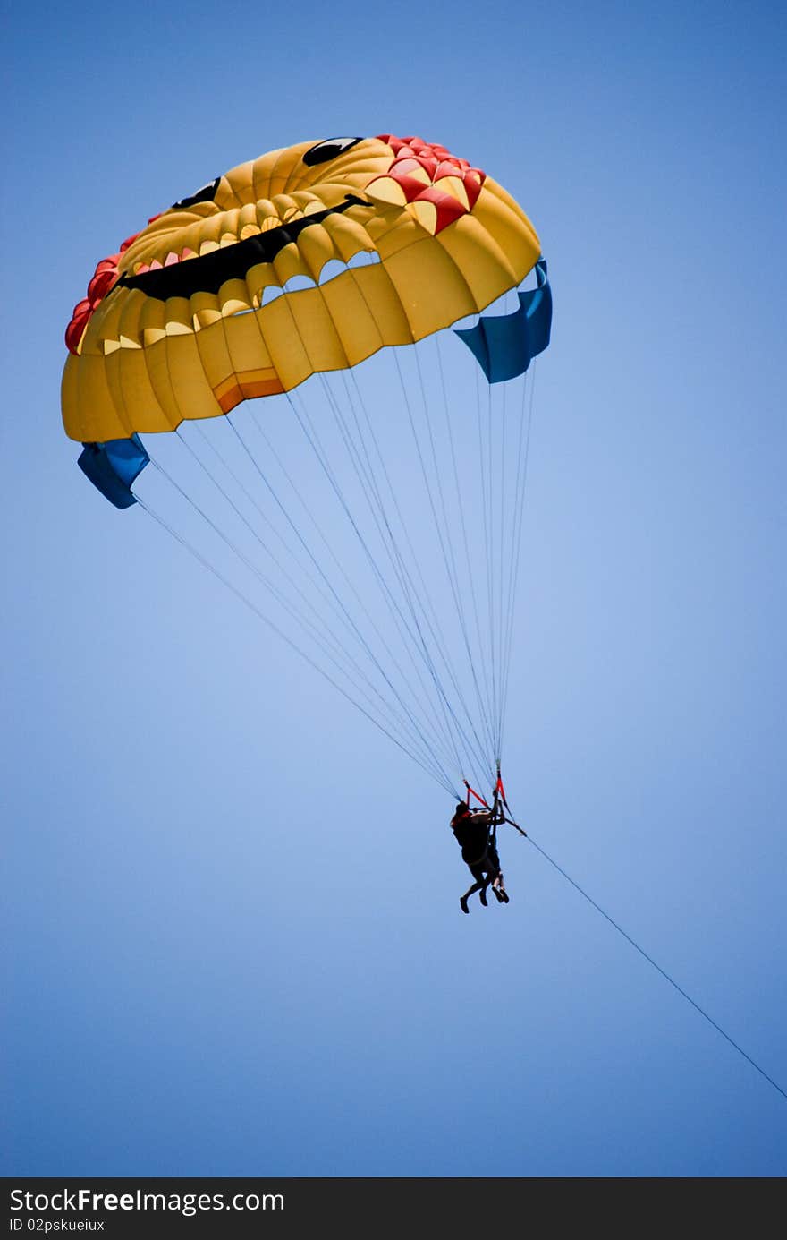 Man parasailing above Mediterranean sea.