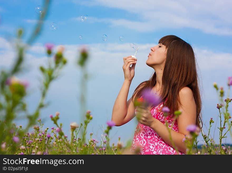 Girl blowing bubbles of soap in sunny weather. Girl blowing bubbles of soap in sunny weather