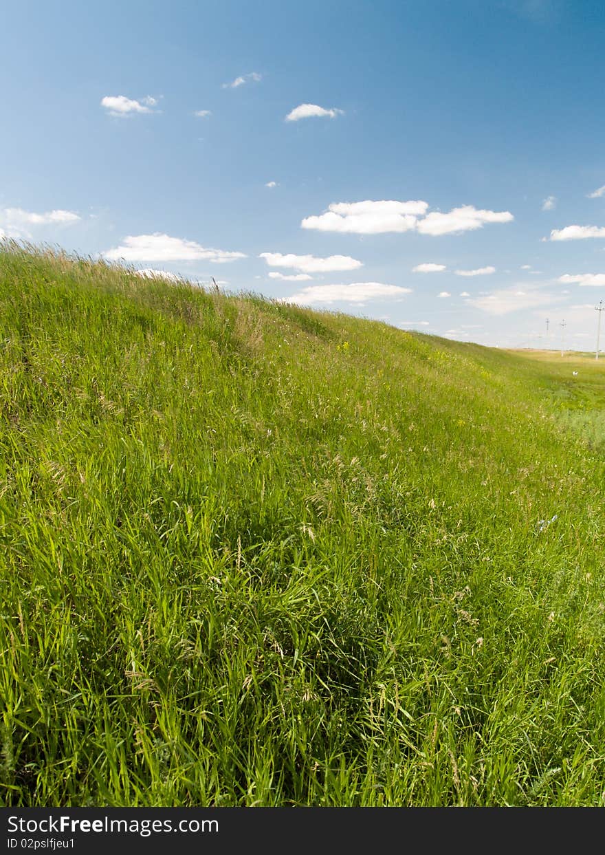 Green field blue sky with clouds