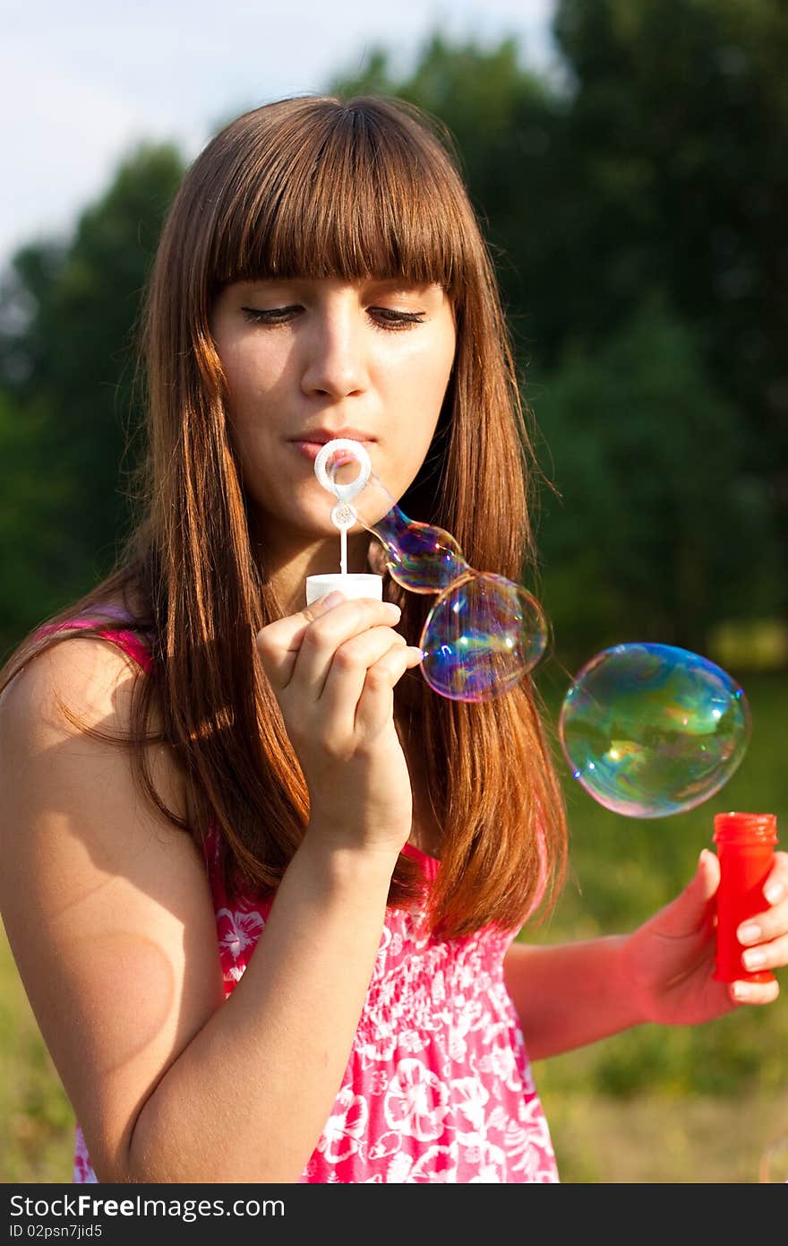 Girl blowing bubbles of soap in sunny weather. Girl blowing bubbles of soap in sunny weather