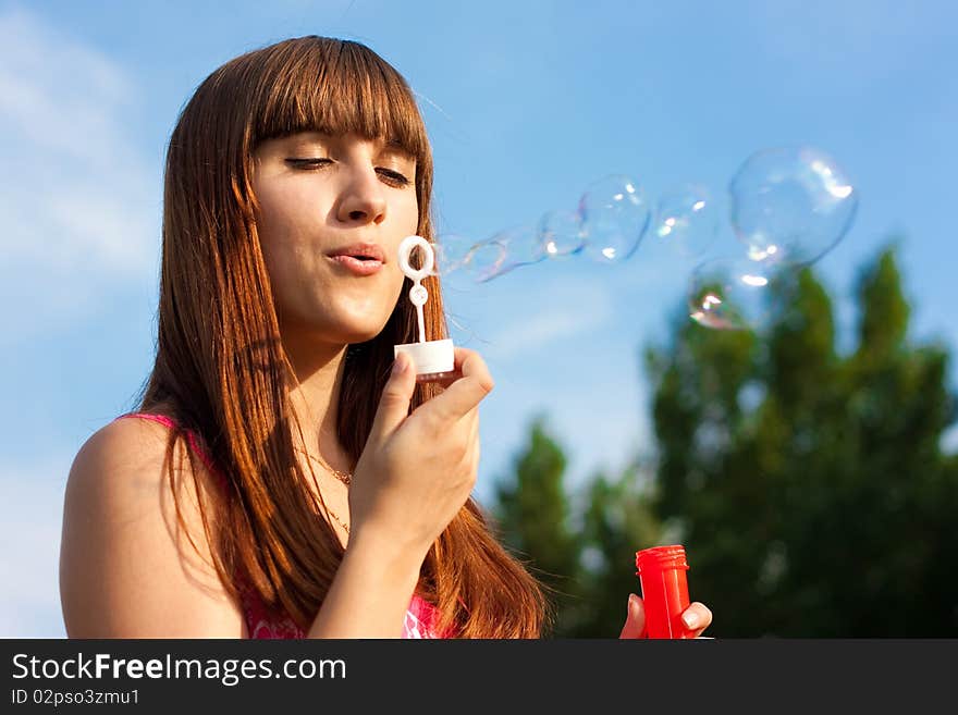 Girl blowing bubbles of soap in sunny weather. Girl blowing bubbles of soap in sunny weather