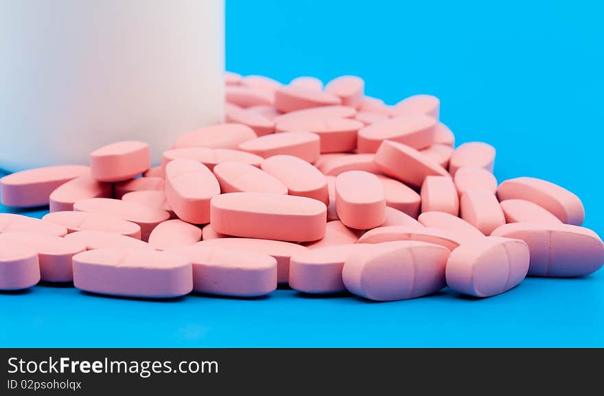 Pills in the medical can on blue background.