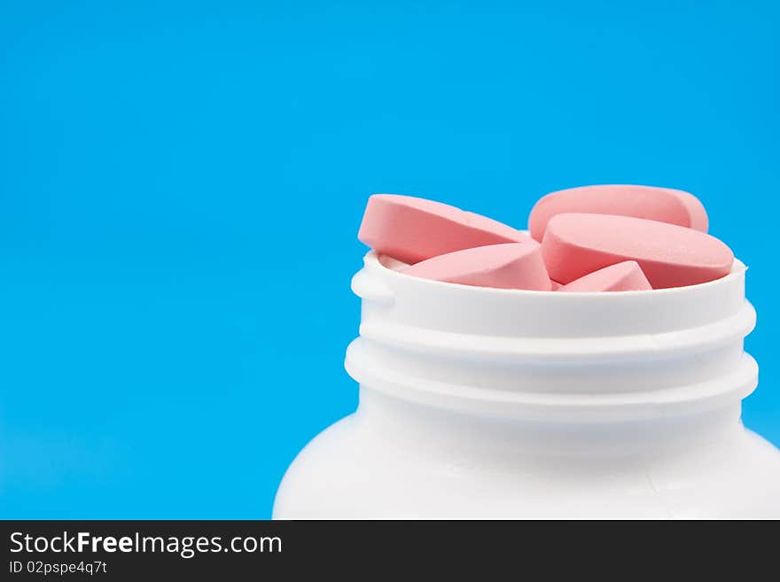 Pills in the medical can on blue background.