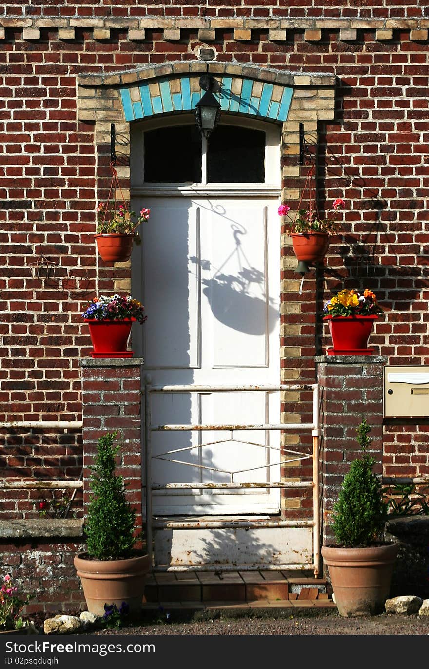 House details with flower pots, shadows on the door and wall. House details with flower pots, shadows on the door and wall