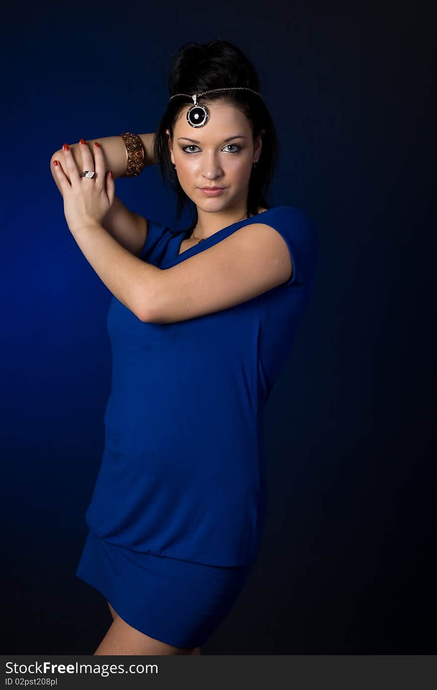 Beautiful girl with blue eyes and dark hair. Girl dressed in a blue dress. Beautiful girl with blue eyes and dark hair. Girl dressed in a blue dress