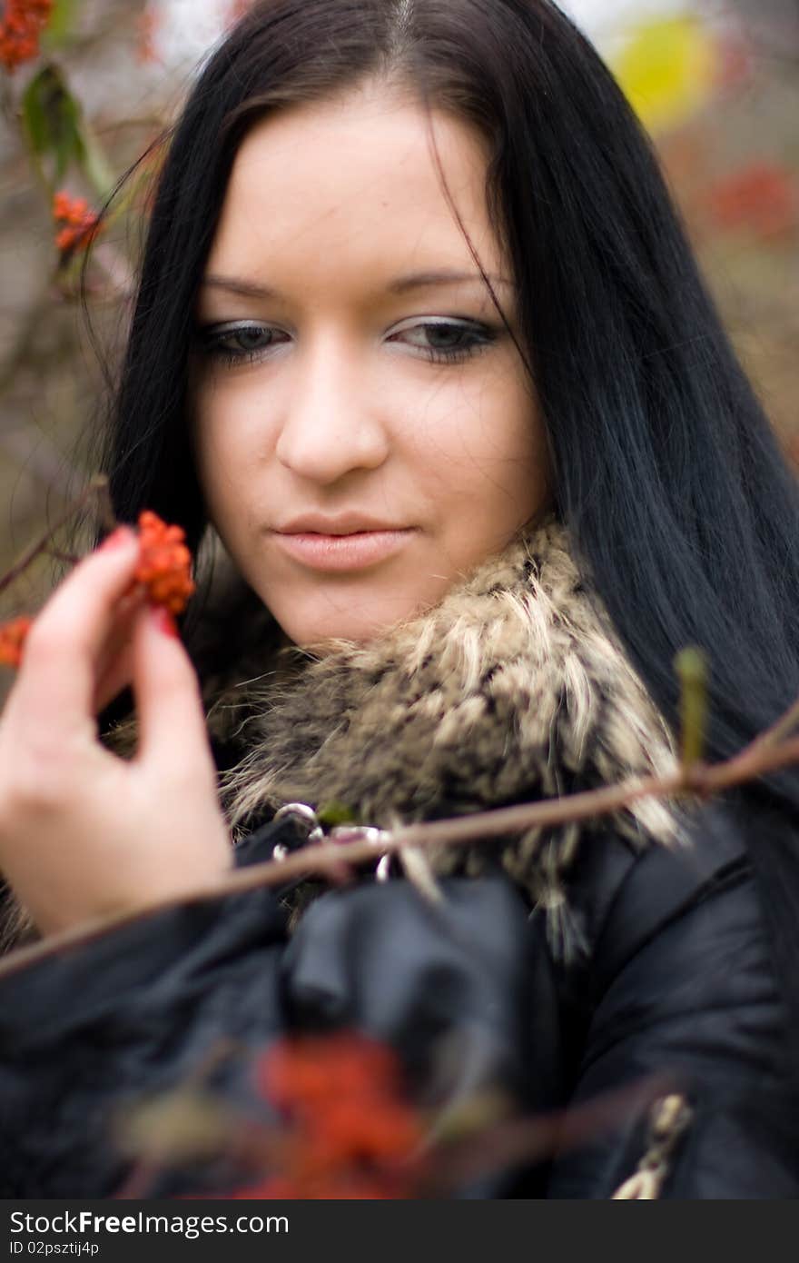 Portrai of beautiful smiling young girl with mountain ash in fall park. Portrai of beautiful smiling young girl with mountain ash in fall park