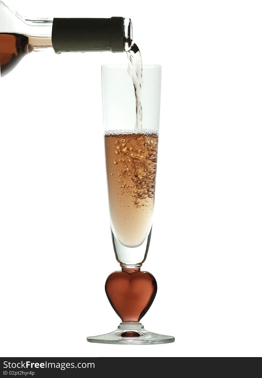 Pouring rose wine into a glass with a red, heart shaped stem