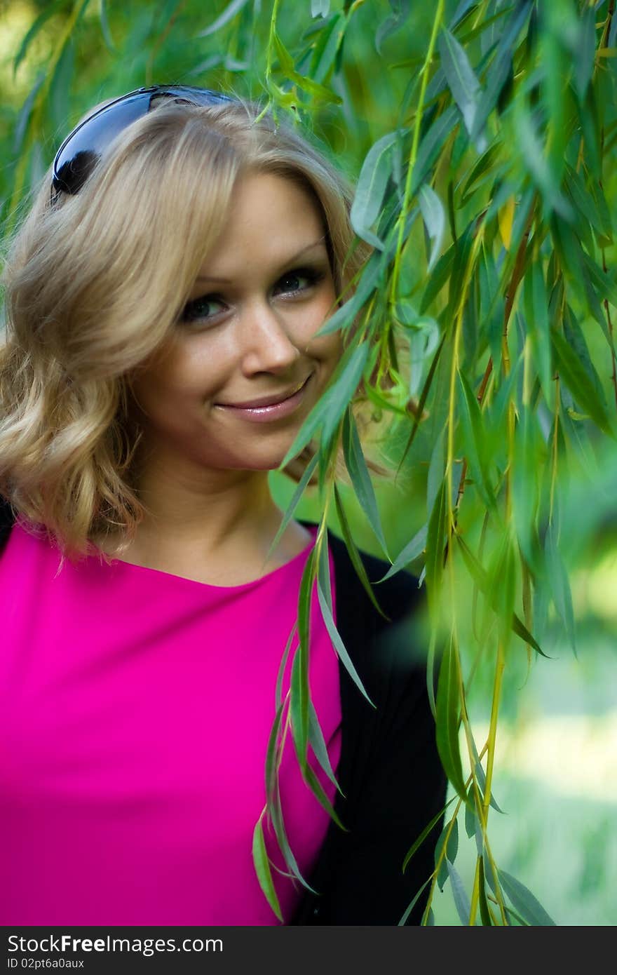 An attractive girl's portrait, her face seen through some green leaves. An attractive girl's portrait, her face seen through some green leaves