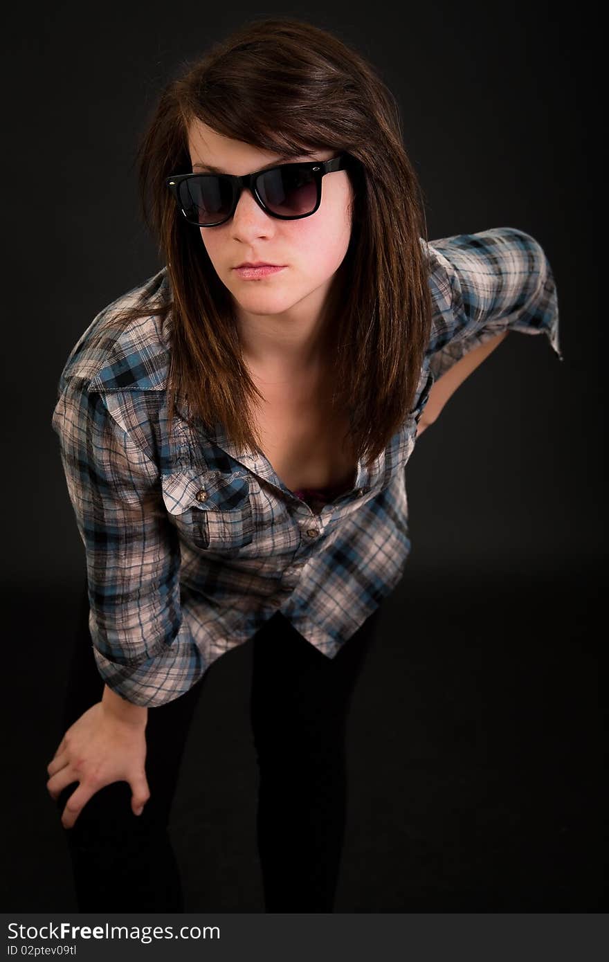 Beautiful teen girl with her sunglasses over dark background