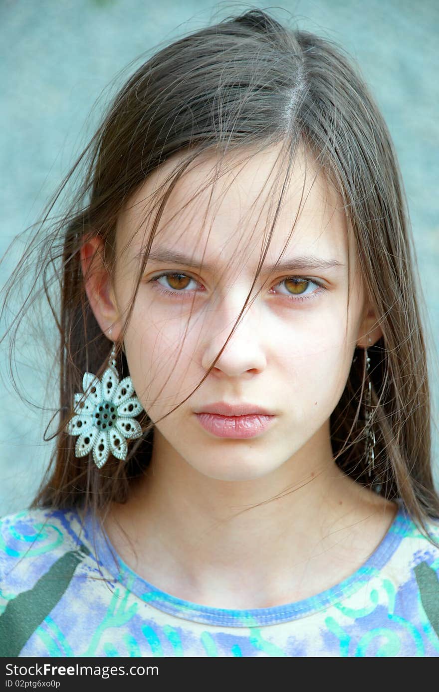 Closeup portrait of a beautiful teenage girl with long hair and earrings. Closeup portrait of a beautiful teenage girl with long hair and earrings