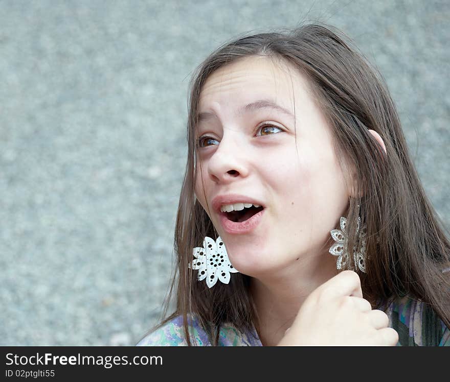 Closeup portrait of a beautiful surprised girl with big earrings