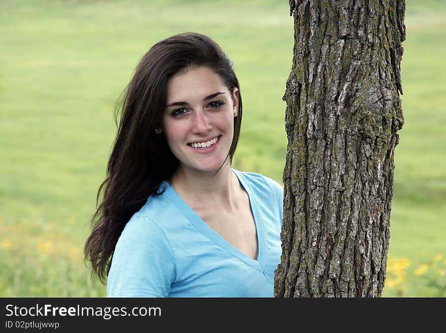 Young Woman Smiling Beside A Tree