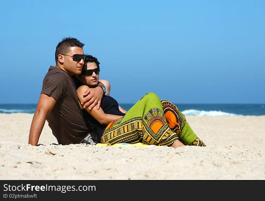 Attractive lovely couple relaxing on the beach. Attractive lovely couple relaxing on the beach