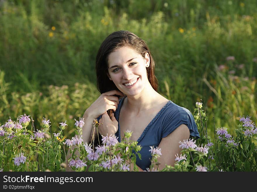 Woman in meadow stroking her hair