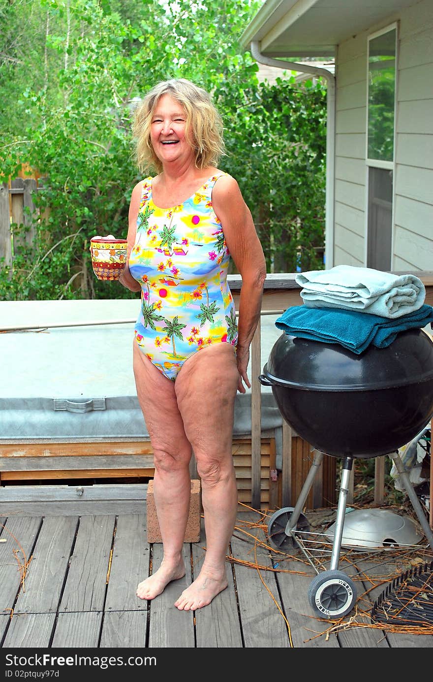 Mature female beauty enjoying her morning coffee and the hot tub.