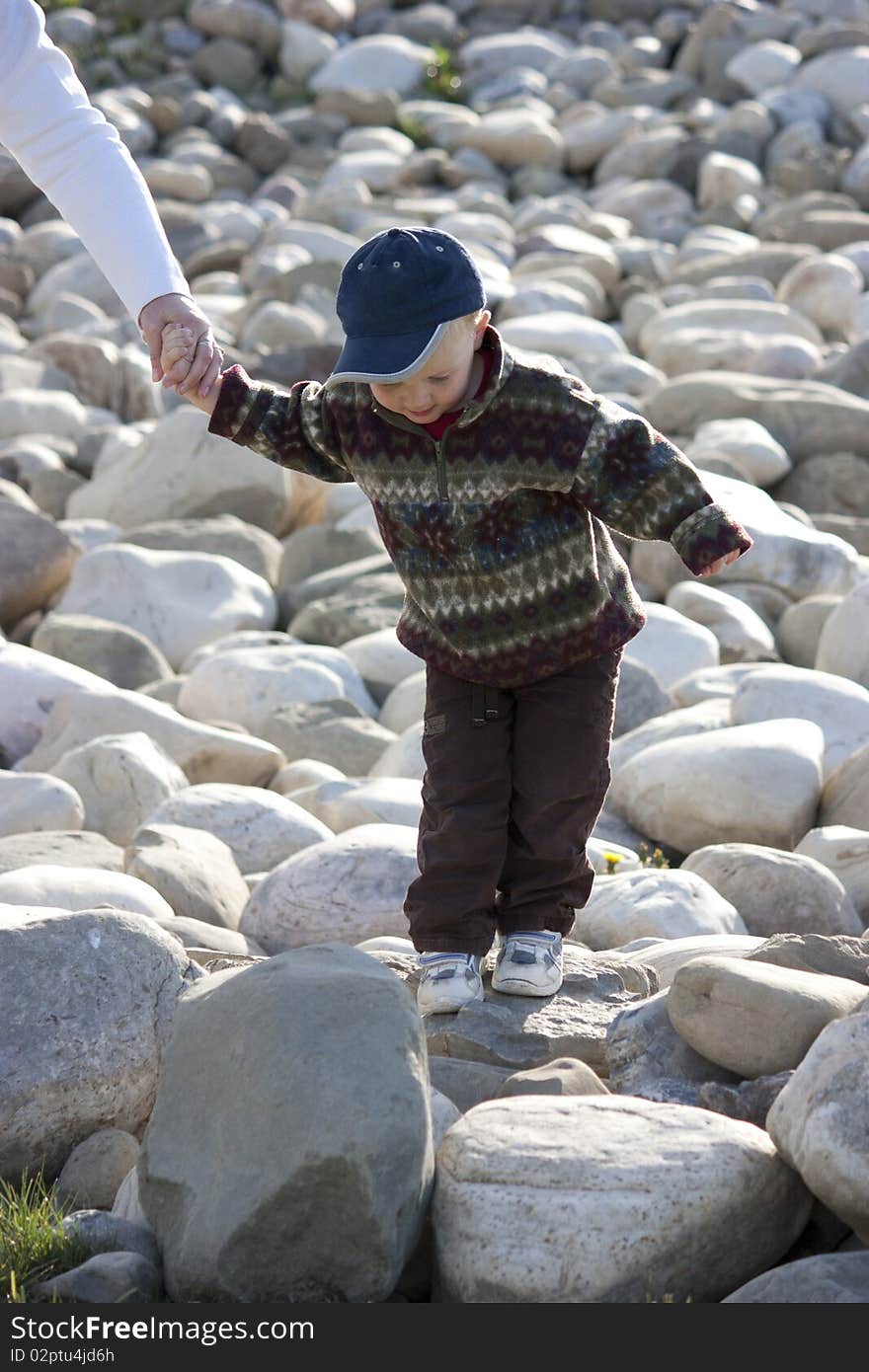 Young boy having fun walking on rocks in the sun. Young boy having fun walking on rocks in the sun.