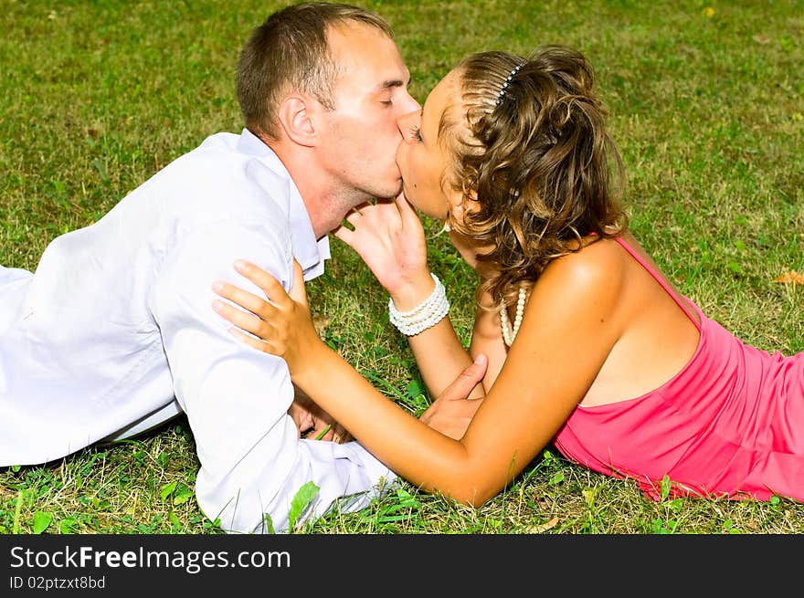 Portrait of young couple kissing on the grass. Portrait of young couple kissing on the grass